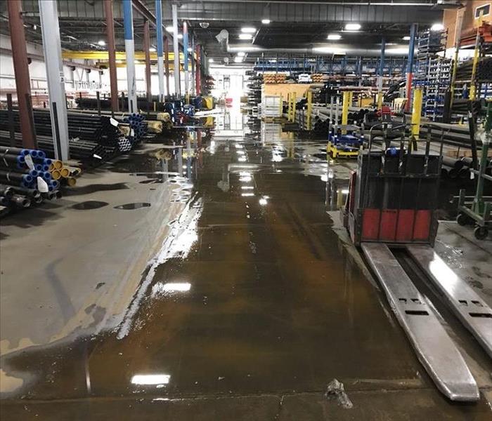 A warehouse floor has standing water on it.