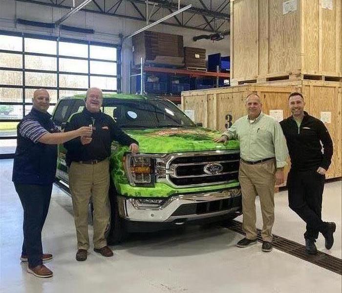 SERVPRO team members pose near a newly wrapped Hybrid Ford F-150